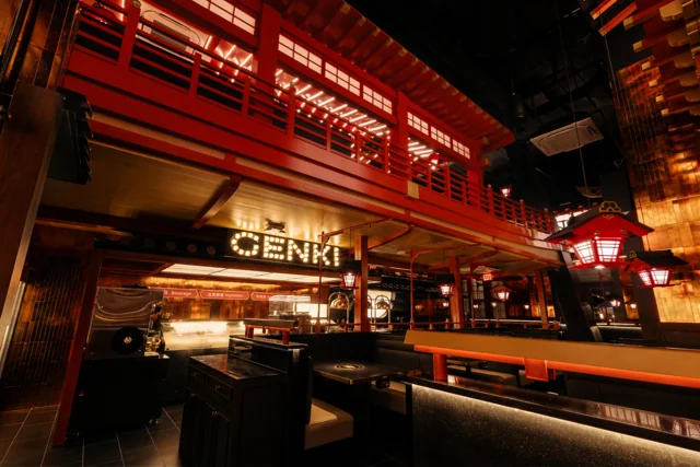 Genki's dramatic red and timber dining room, with warm lighting and an upper-level walkway