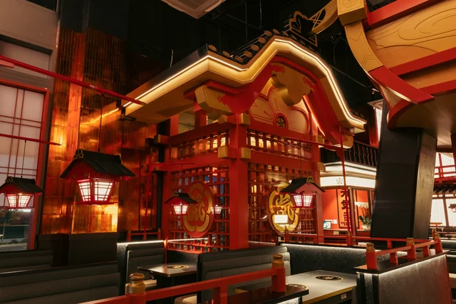Glowing lanterns and red-and-gold Japanese-inspired architecture above Genki's dining booths